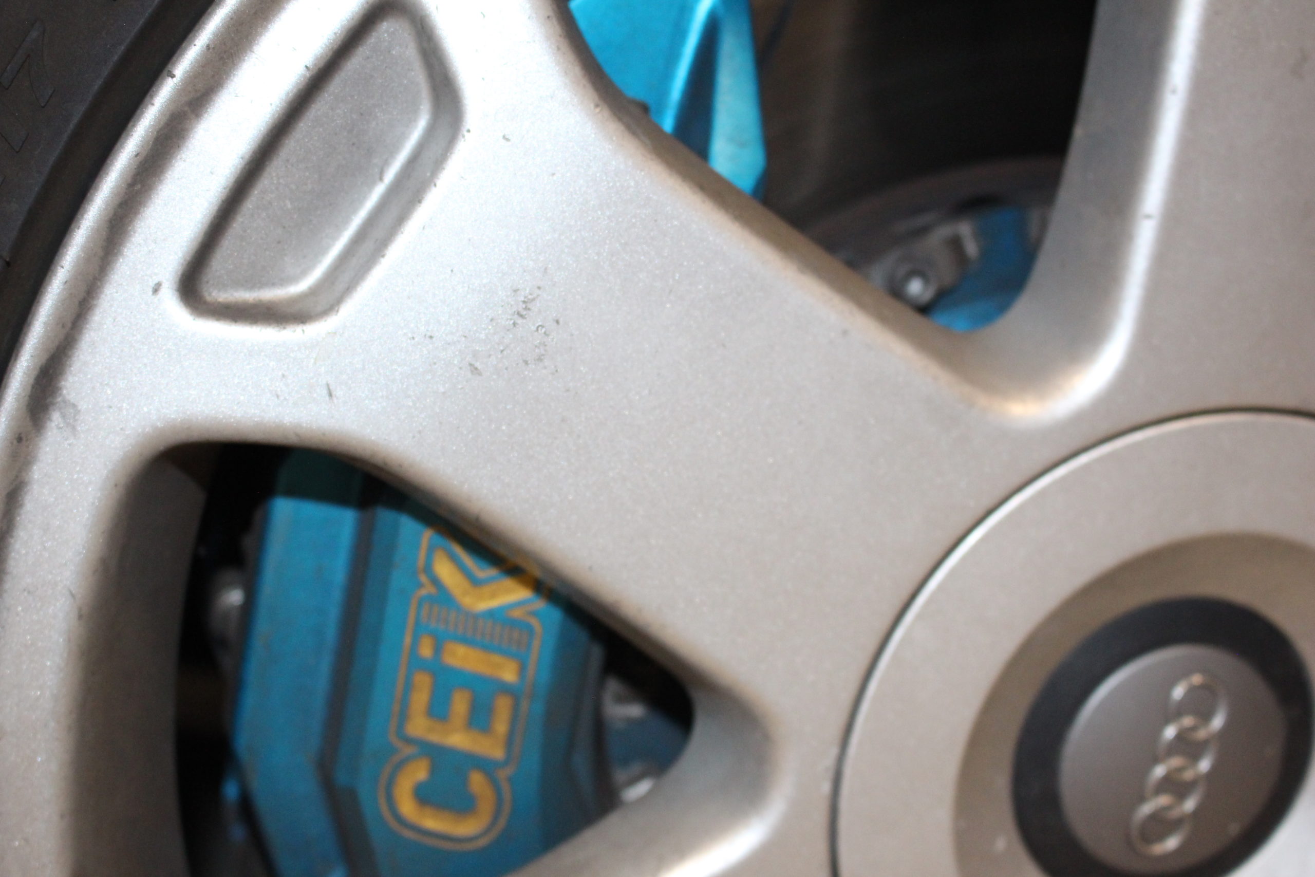 Silver wheel with blue brake caliper