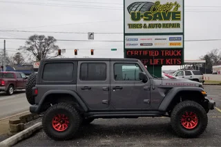 Grey Jeep Wrangler with red wheels