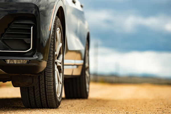 close up view of a vehicles tires on a sandy road